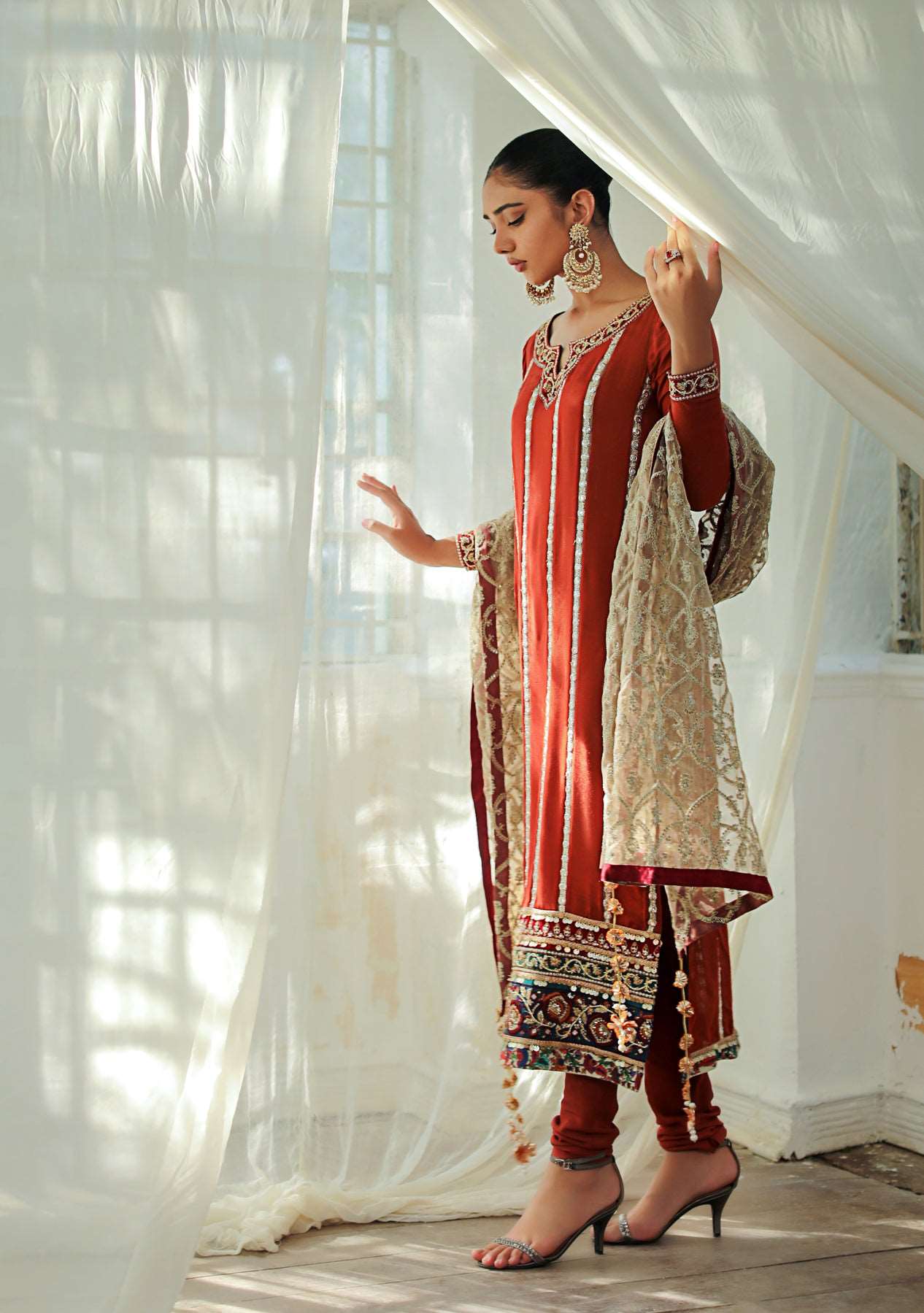 Rust shirt with churidar and gold dupatta